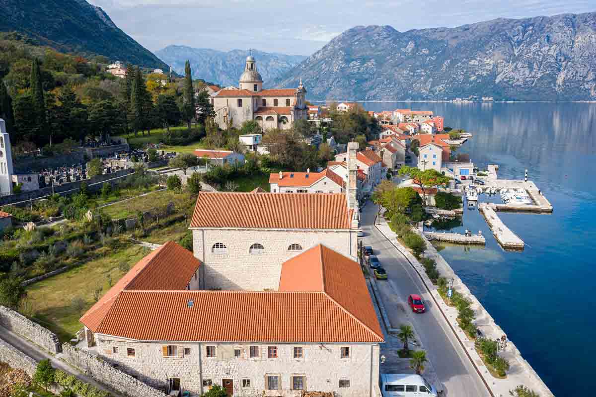 The drone shot of Prčanj village in Kotor, Montenegro. The Monastery from 18th century is dominating the view.